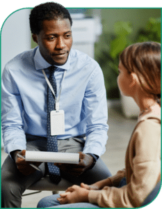 male therapist talking to a girl in teen mental health treatment