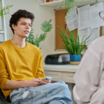 teen in yellow shirt meeting with a professional to talk about teen depression