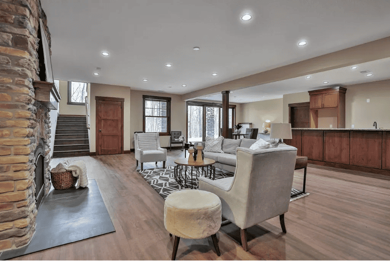 Mission Prep spacious modern living room with stone fireplace, comfortable seating, and open floor plan