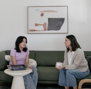 mom and daughter talking on a couch about mental health challenges