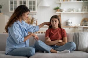 Young loving supportive mother trying to help anxious teen daughter