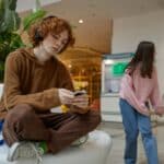 upset teenage guy sitting alone with headphones on, exhibiting teen adhd in need of residential treatment