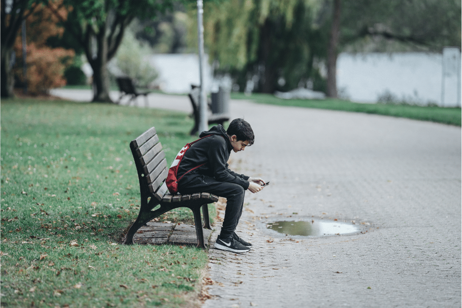 Teenage boy sitting on a park bench