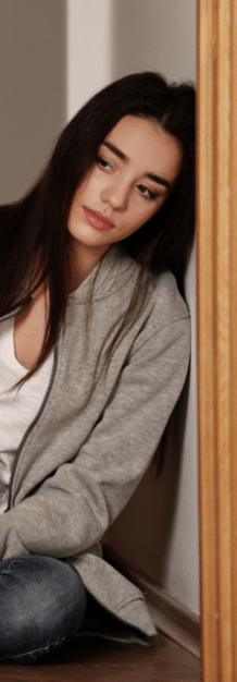 teen girl leaning against a wall while in need of teen anger treatment