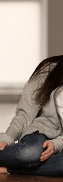 teen girl leaning against a wall while in need of teen anger treatment