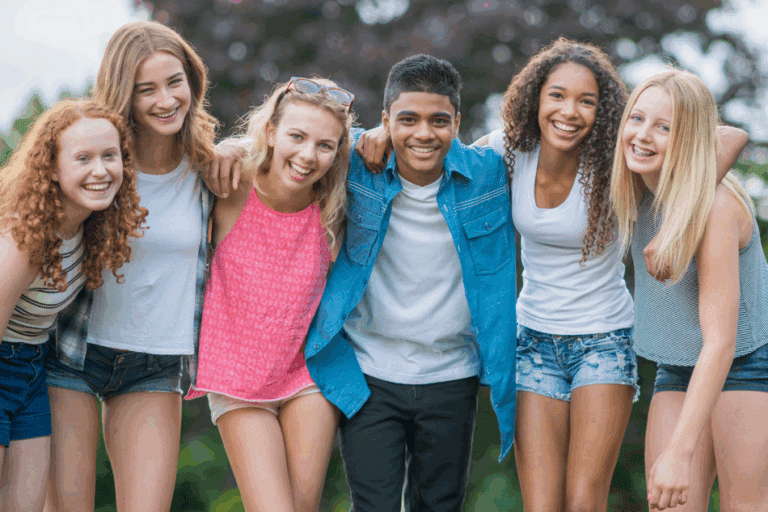 Group of teenagers smiling and happy after somatic therapy for teens