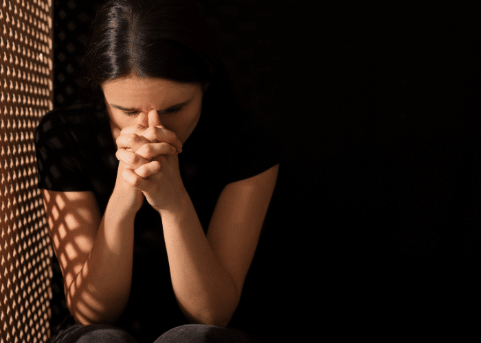 teenage girl with her head in her hands struggling with coping with adjustment disorders in teens