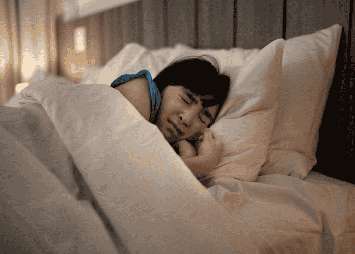 Teenage girl experiencing teen nightmares while in bed