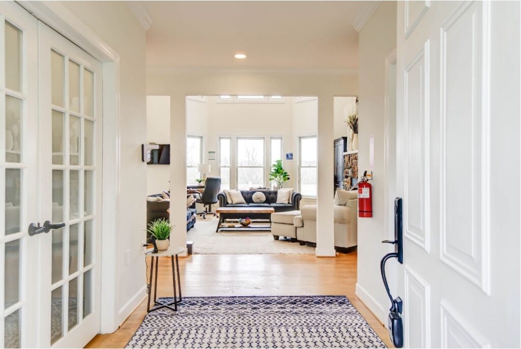 Bright, modern home entryway with hardwood floors leading to an open-concept living room with natural light.