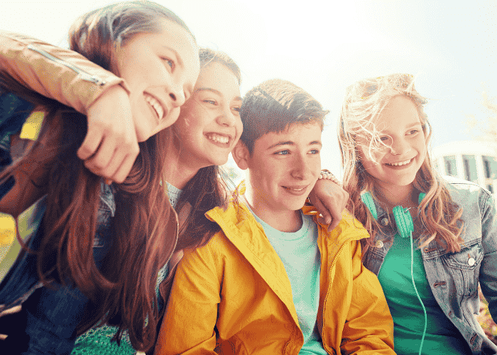 group of four teenagers looking off in the distance smiling after overcoming racing thoughts in teens