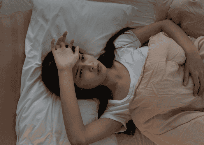 Teenage girl in bed with insomnia unable to sleep due to sleep problems in teens