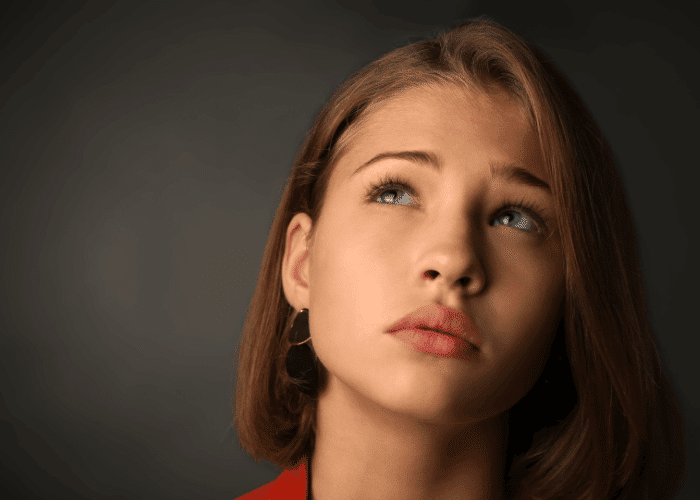 close-up of teenage girl looking worried due to experiencing teen fear of abandonment