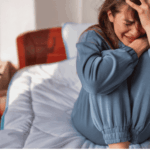 Teenage girl sitting on bed experiencing crying spells
