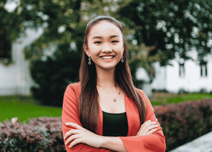 Teenage girl standing in garden smiling after treatment for teenage guilt and shame
