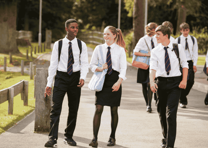 Two teenage boys and one teenage girl walking to school in school uniform, happy due to treatment for teen dissociation