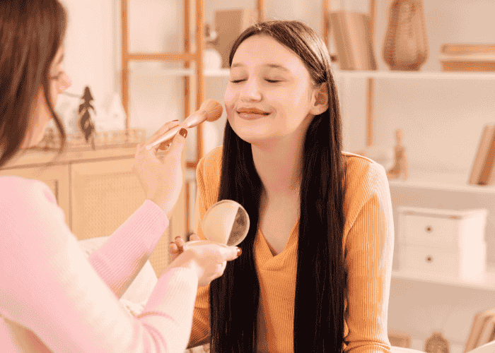 teenage girl smiling while getting her makeup done because she's overcome skin picking in teens