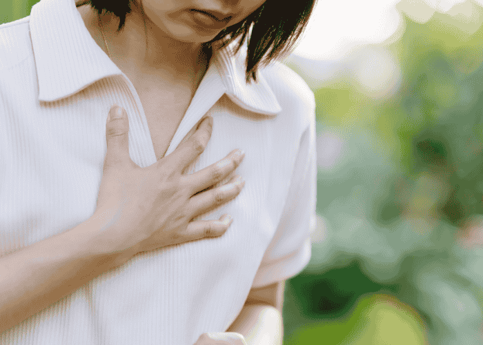 Teenager with her hand on her heart due to heart palpitations in teens