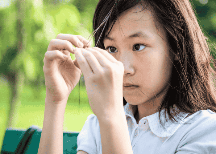 Teenage girl picking her hair obsessively due to controlling behavior in teens