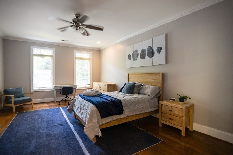 Modern bedroom with natural wood furniture, blue accents, and minimalist decor.
