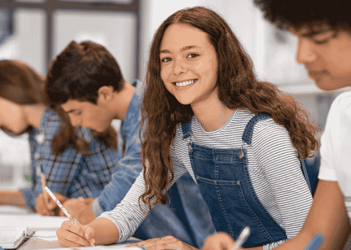 Teenage girl in class smiling after treatment for concentration problems in class.