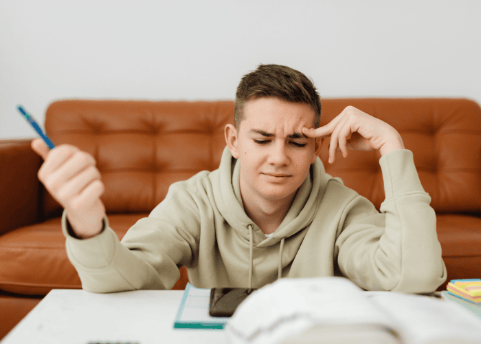 Teenage boy's mind going blank while he's sitting at desk doing homework