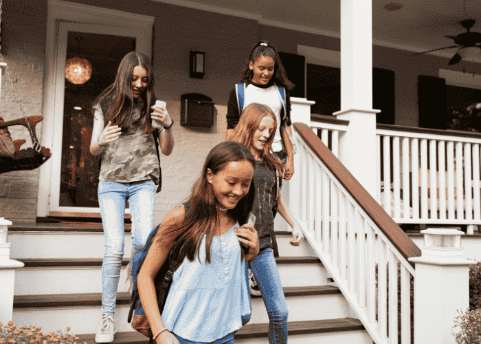 teenage girl leaving house for school on time with friends after support for losing track of time due to stress or anxiety