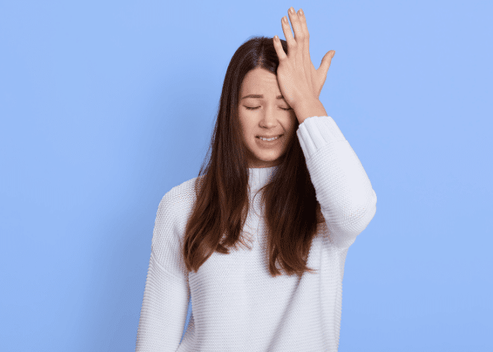 Teenage girl with hand on head experiencing forgetfulness in teens