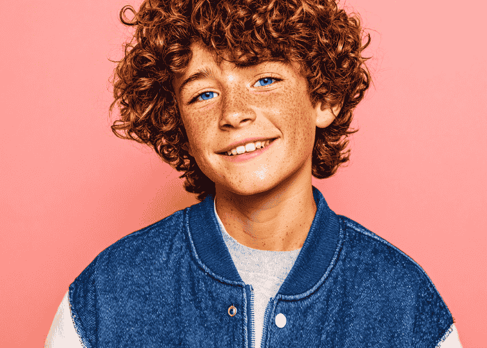 Teenage boy smiling after treatment for teeth grinding in teens