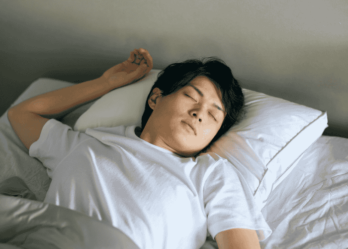 Teenage boy sleeping soundly in bed after support with parasomnias in teen