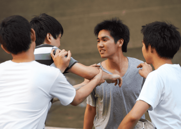 teenage boy leaning aggressively towards another teenage boy as if looking to start a fight experiencing risky decision-making in teens