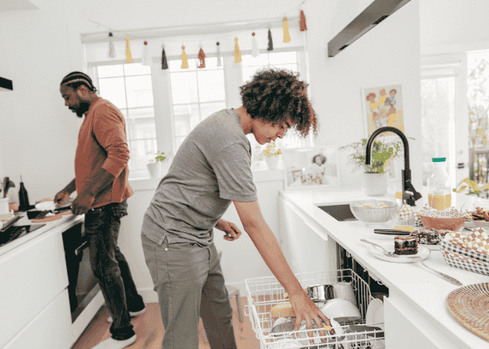 teenage boy in kitchen with his dad loading dishwasher after support for teen avoiding responsibilities