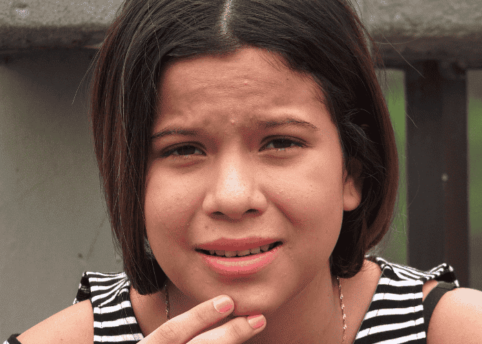 Teenage girl sitting outside looking sad experiencing feelings feeling hopeless about the future