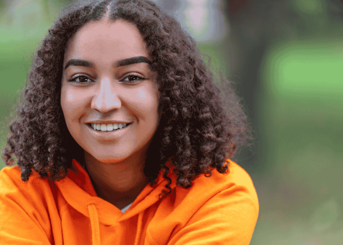 Teenage girl smiling after treatment for ongoing dissatisfaction with life in teens