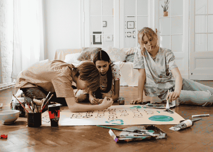 Teenage girls working together on art project after treatment for teen difficulty accepting help