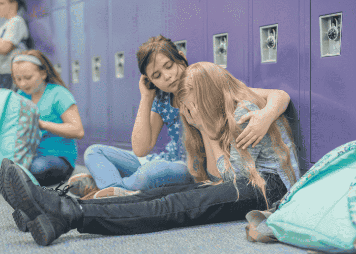 teenage girl being consoled by friend because she's feeling like a burden