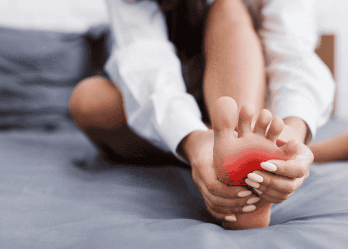 Teenage girl clutching her foot due to anxiety-related pins and needs in teens