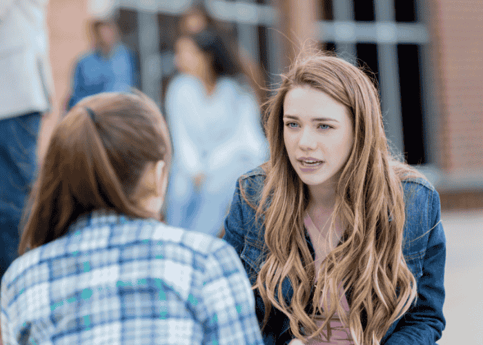 Two teenage girls having a serious conversation struggling with rigid thinking in youth