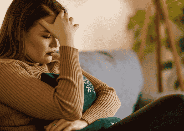 Teenage girl with her hand on her head looking overwhelmed due to scary mental images in teens