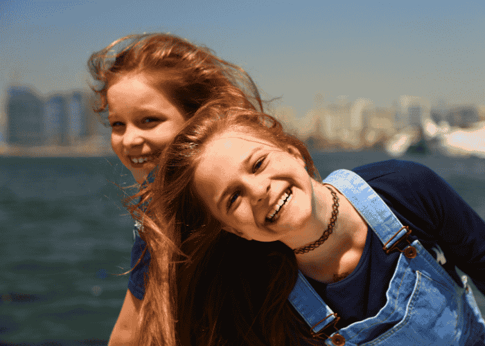 Teenage girls on a boat having fun and laughing due to receiving treatment for scary mental images in teens