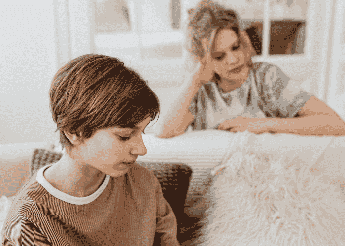 Teenage girls looking away from each other awkwardly due to over apologizing in teens