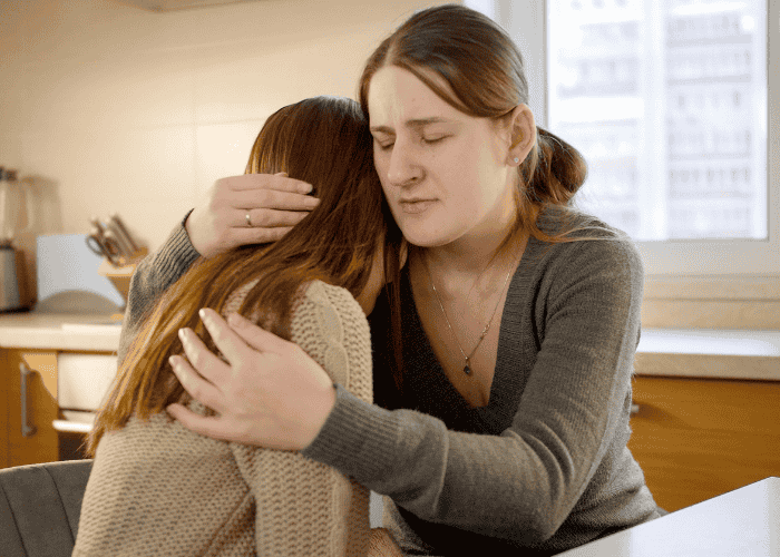 mom hugging teen daughter whilst worrying about Sutter Health mental health coverage