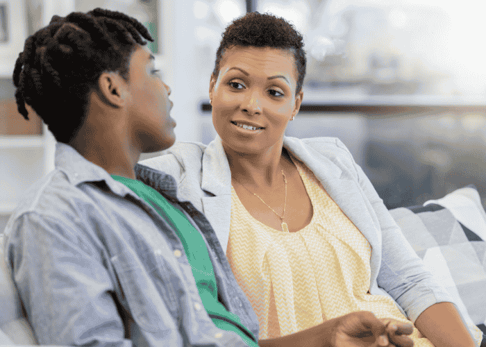 mom sitting on sofa next to teen son listening to him talk after seeking support with Sutter Health mental health coverage