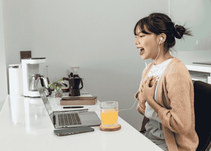 Teen girl sitting at table on video call looking happy after seeking help with Employers Health Network (EHN) Coverage