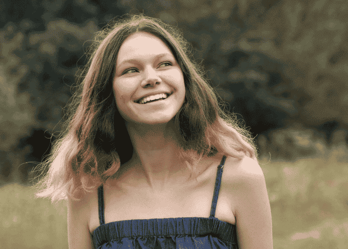 teenager girl standing outside in park smiling after support with neurodiversity and mental health in teens