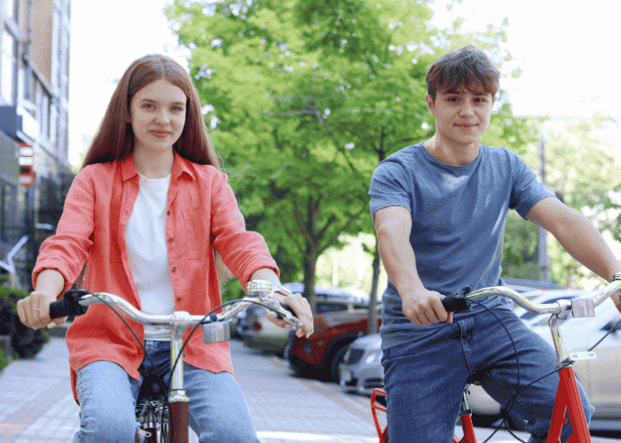 teen girl on bike ride in city with friend smiling after support with anxiety in neurodivergent teens
