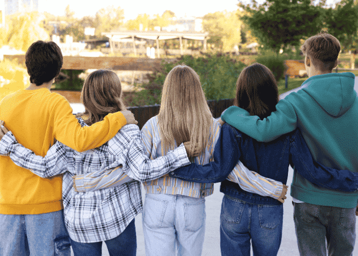 Group of teens walking outside with arms round each other after seeking support for Rejection Sensitive Dysphoria (RSD) in teens