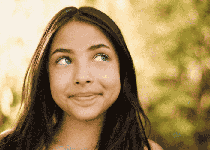 teen girl outside smiling after receiving support with how limerence affects teen mental health
