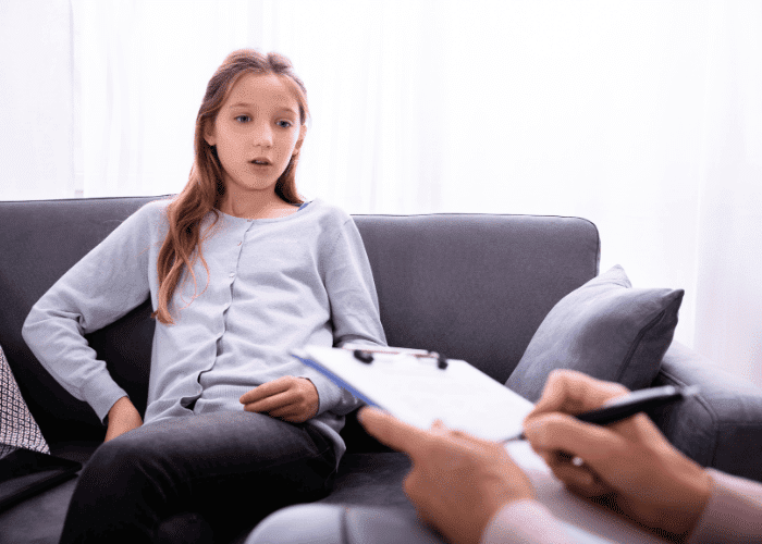 Teenage girl sitting in a therapy session, just one example of California mental health programs for teens