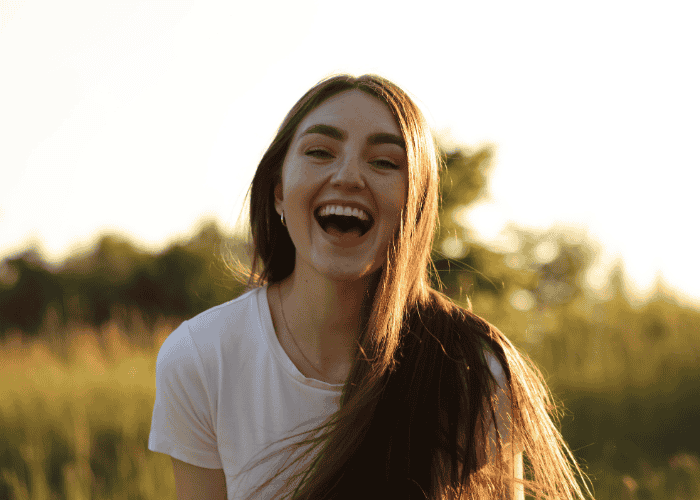 Teenage girl smiling after receiving treatment for autistic burnout vs. depression