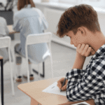 Teenage boy sitting at desk needing support with mental health in the classroom